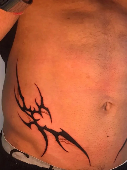 Small Tribal Tribal Wings on Men Torso Tattoo by @ink_of_believe__