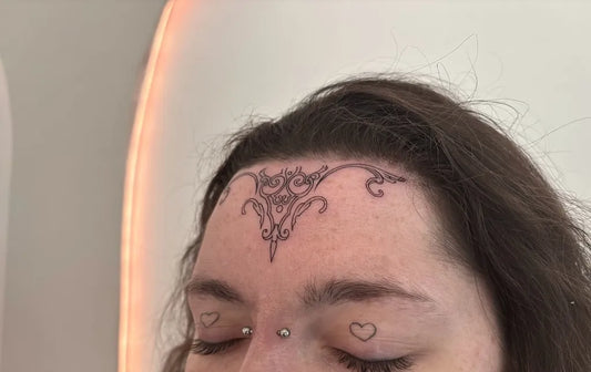 Small Vinework Floral on Women Face Tattoo by @arken.tattoo