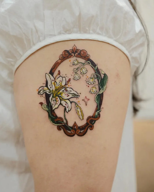 Small Vintage Lily in Ornate Frame on Women Arm Flower Tattoo by @momo.tattooist