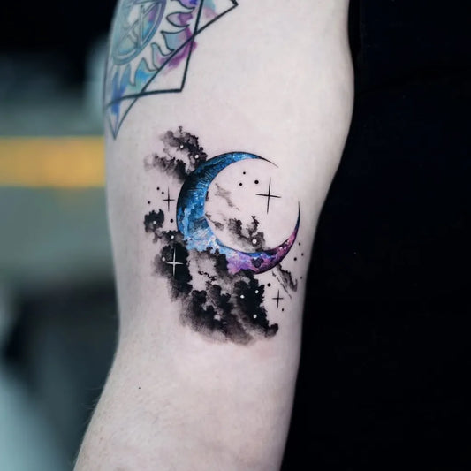Small Watercolor Crescent Moon and Clouds Tattoo on Women Arm by @ink_avenue