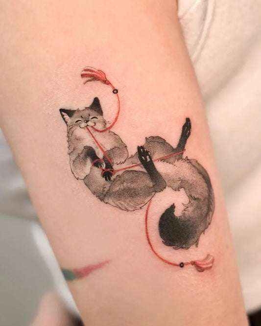 Small Watercolor Fox with Red String Tattoo on Women Arm by @yusoo.tattoo