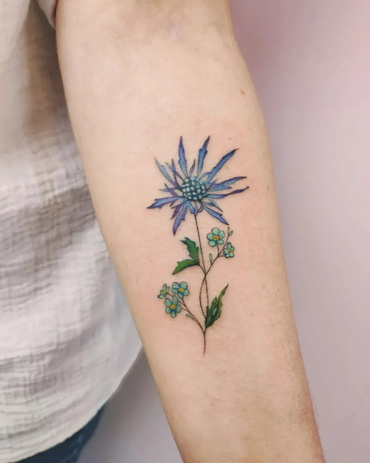 Small Watercolor Globe Thistle and Forget Me Not Flowers on Women Arm Tattoo by @wawrzynowicz.m