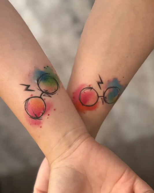 Small Watercolor Harry Potter Glasses and Lightning Bolt on Women Arm Tattoo by @andrei.c.tattoo