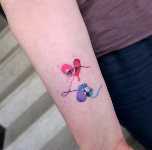 Small Watercolor Intertwined Hearts on Women Arm Tattoo by @rolypolyc