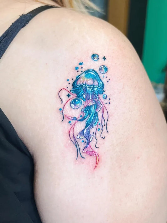 Small Watercolor Jellyfish Tattoo on Women Shoulder by @mnstr_tattooer
