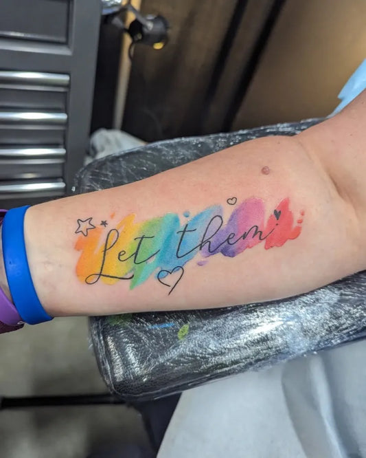 Small Watercolor Let Them Rainbow Hearts on Women on Arm Tattoo by @tama.inks