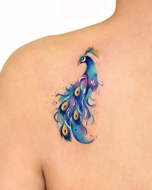 Small Watercolor Peacock Tattoo on Women Shoulder by @tattooist_hei