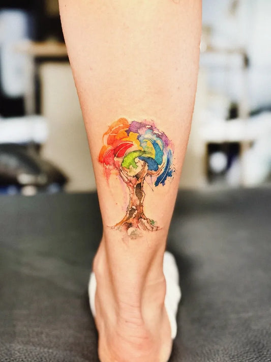Small Watercolor Rainbow Tree on Women Leg Tattoo by @rainisline
