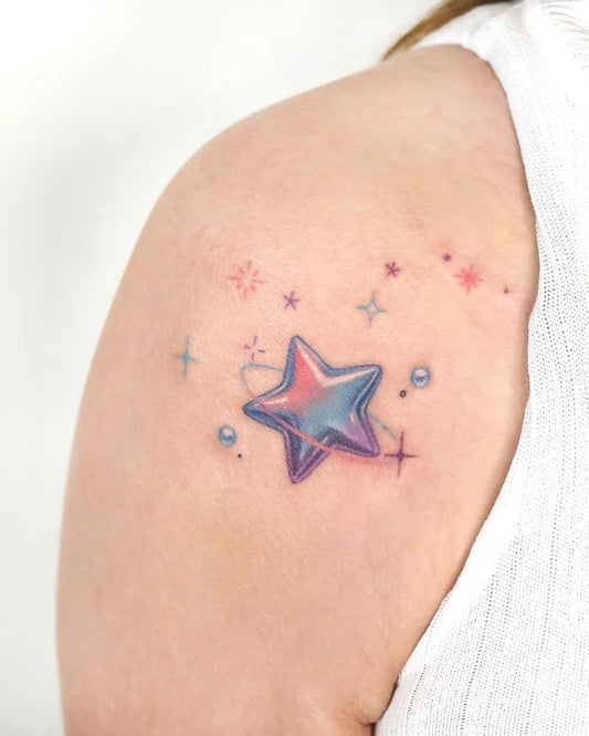 Small Watercolor Star Tattoo on Women Shoulder by @zommi.tt