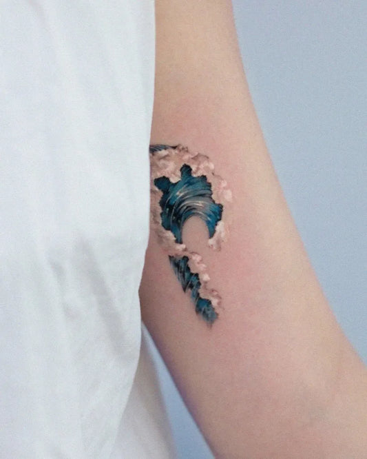 Small Watercolor Wave Tattoo on Women Arm by @harusisun