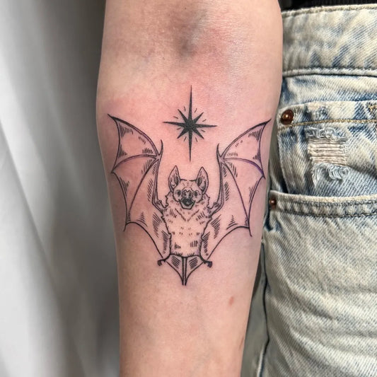 Small Woodcut Bat and Star Tattoo on Women Arm by @goodvibestattoo.studio