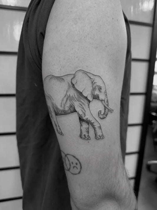 Small Woodcut Elephant and Sad Face Tattoo on Men Arm by @uma_leloup