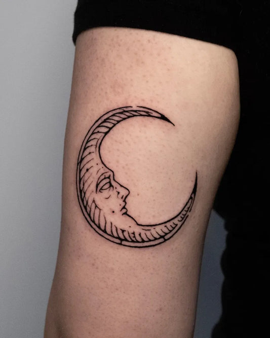 Small Woodcut Moon Face Tattoo on Women Arm by @ola.krupnik
