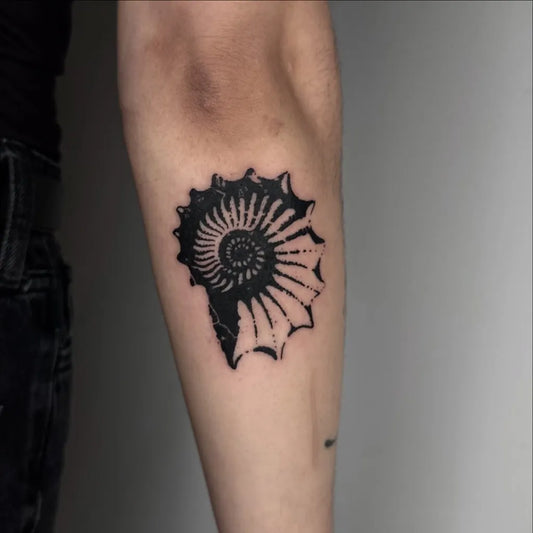 Small Woodcut Shell Tattoo on Women Forearm by @kajetankarczewski