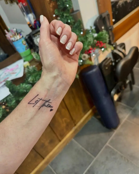 Small Word Let Them on Women Wrist Tattoo by @black.pearltattooparlour