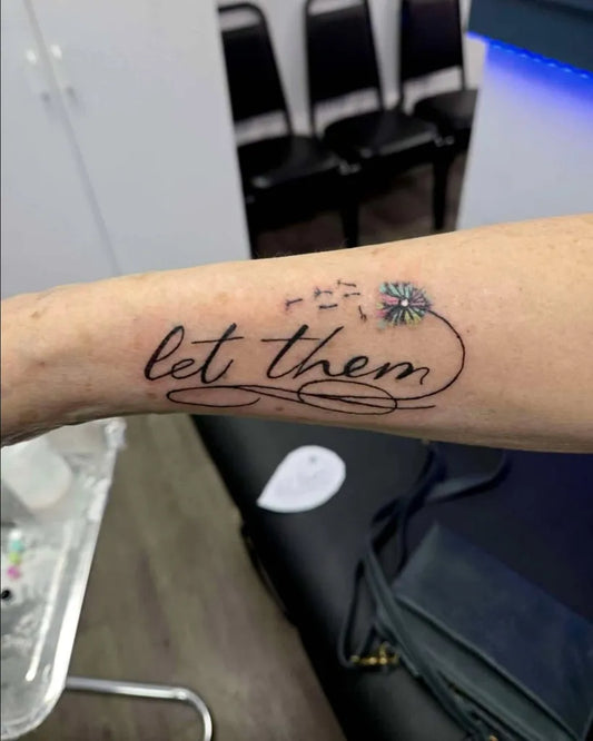 Small Word with Flowers on Women Forearm Tattoo by @anchoredinktattoo