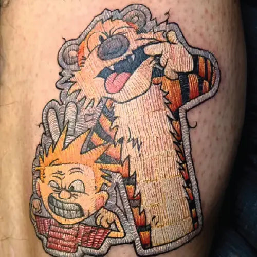 patchwork style Calvin and Hobbes tattoo