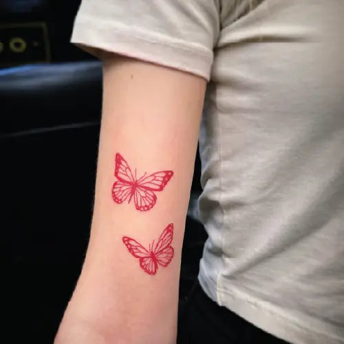red butterflies couple arm tattoo