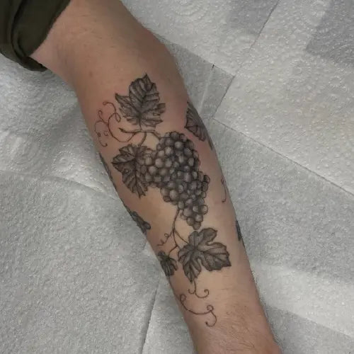 black and grey grape vine arm sleeve tattoo