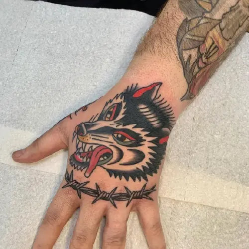 traditional wolf and wire hand tattoo