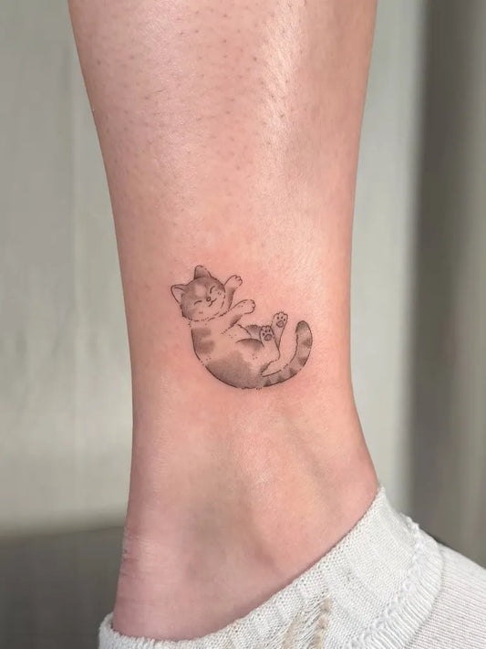 Tiny Black and Grey Cat Tattoo on Women Ankle by @spamueltattoos