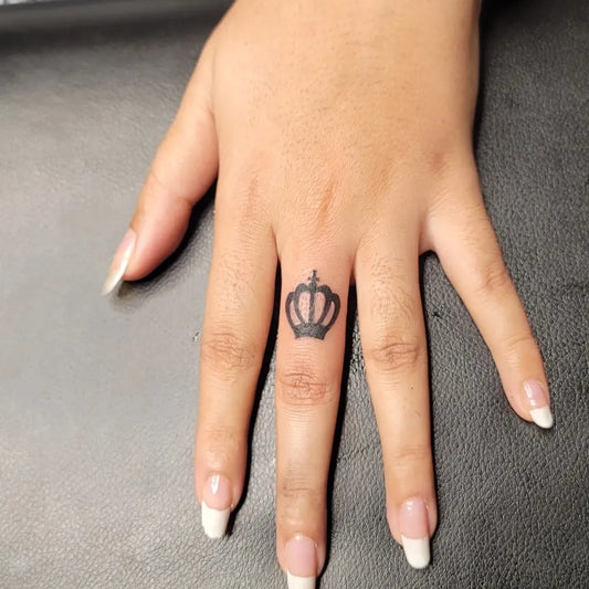 Tiny Black and Grey Crown Tattoo on Women Hand by @_ink_masters