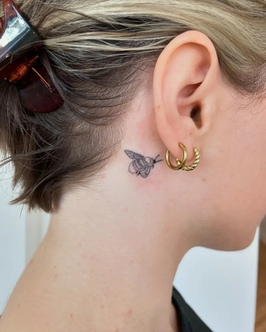 Tiny Blackwork Bee Tattoo on Women Behind the Ear by @bearangeltattoo
