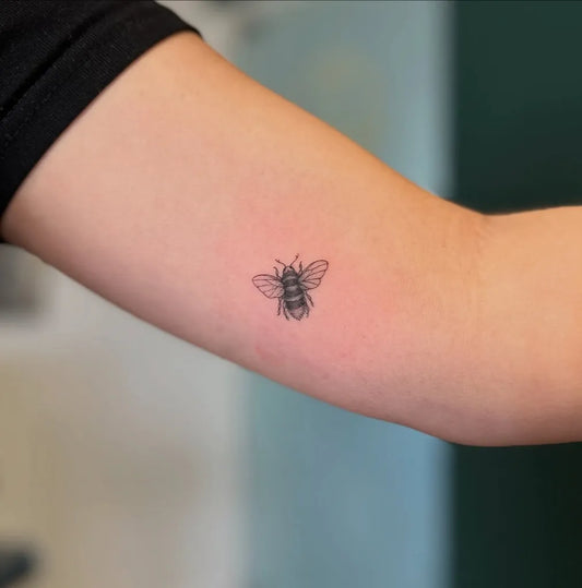 Tiny Blackwork Bee on Women Arm Tattoo by @piskhold