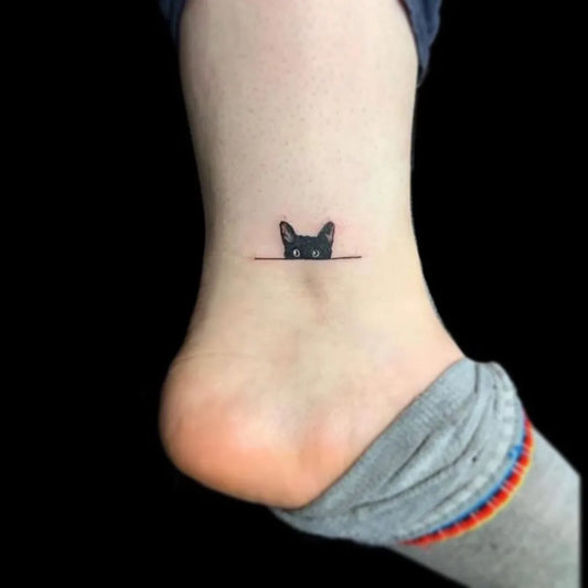 Tiny Blackwork Cat Tattoo on Women Ankle by @k_ink_tattoo