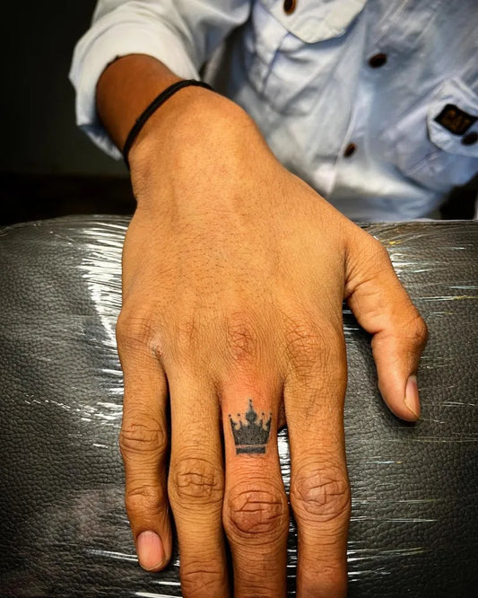 Tiny Blackwork Crown Tattoo on Men Finger by @body.craft.tattooz