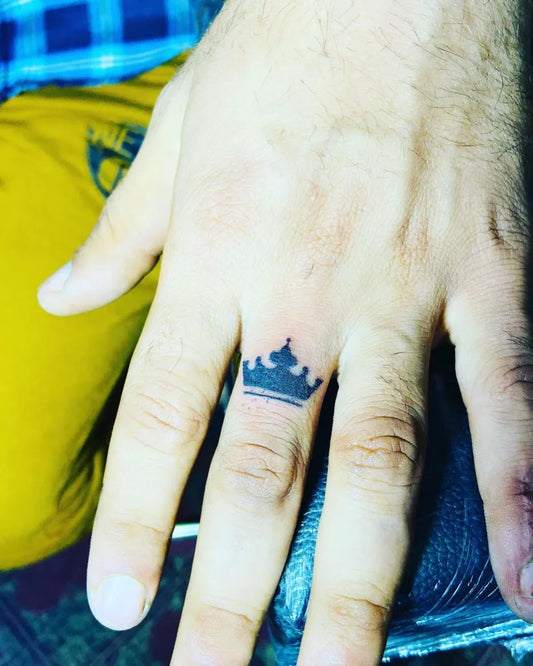 Tiny Blackwork Crown Tattoo on Men Finger by @fakeeratattooz
