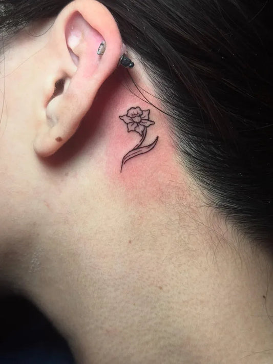 Tiny Blackwork Daffodil Tattoo on Women Behind the Ear by @vermillion.tattoos