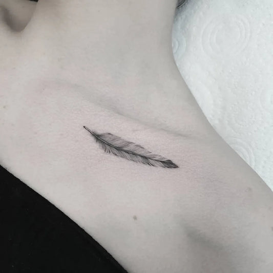 Tiny Blackwork Feather Tattoo on Women Collarbone by @leehumphs_tattoo