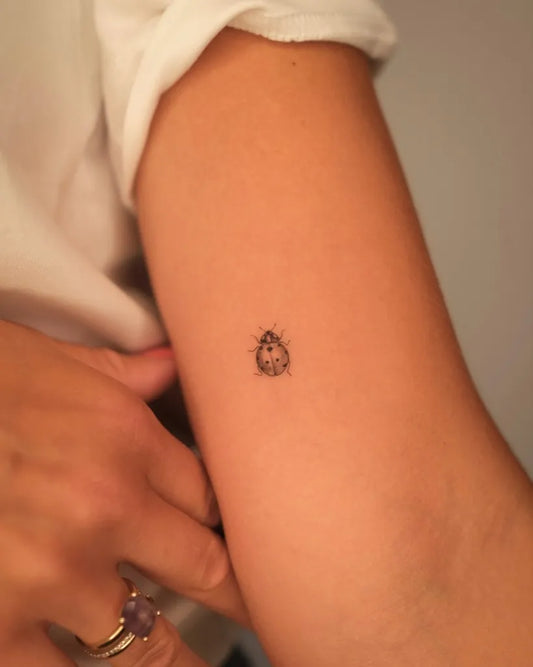 Tiny Blackwork Ladybug Tattoo on Women Arm by @luprosil