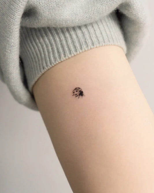 Tiny Blackwork Ladybug Tattoo on Women Arm by @vladkork