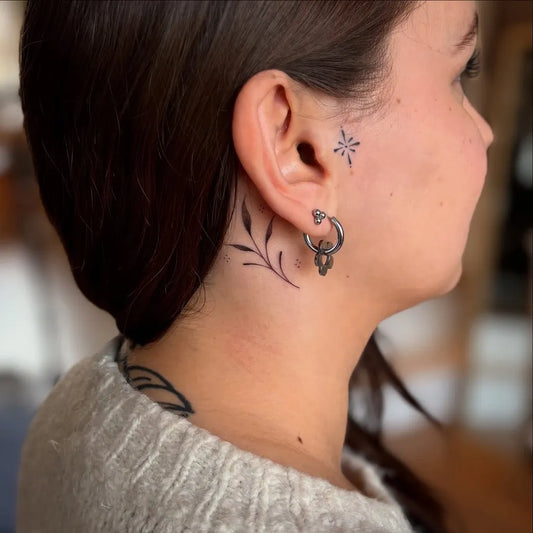 Tiny Blackwork Leaves and Star Tattoo on Women Behind the Ear by @jadejay.ink