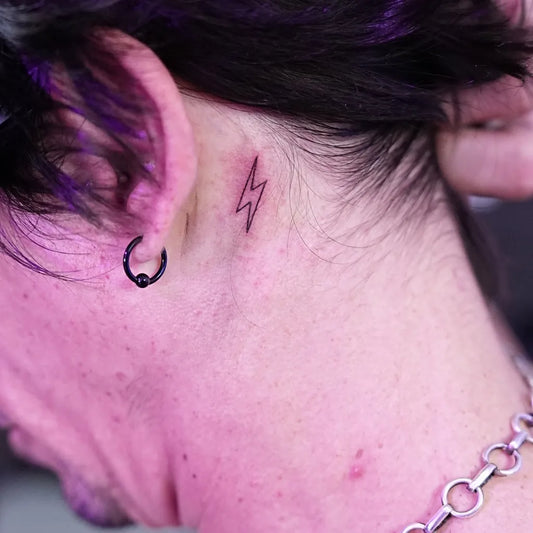 Tiny Blackwork Lightning Tattoo on Women Behind the Ear by @danielarttattoos