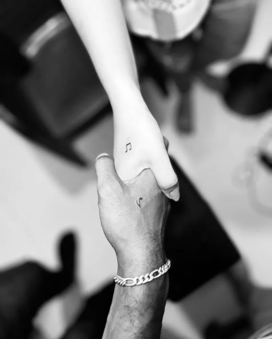 Tiny Blackwork Note Tattoo on Women Wrist by @crazymachinetattooz