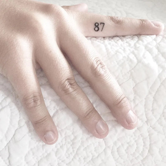 Tiny Blackwork Numbers Tattoo on Women Finger by @kat3roo