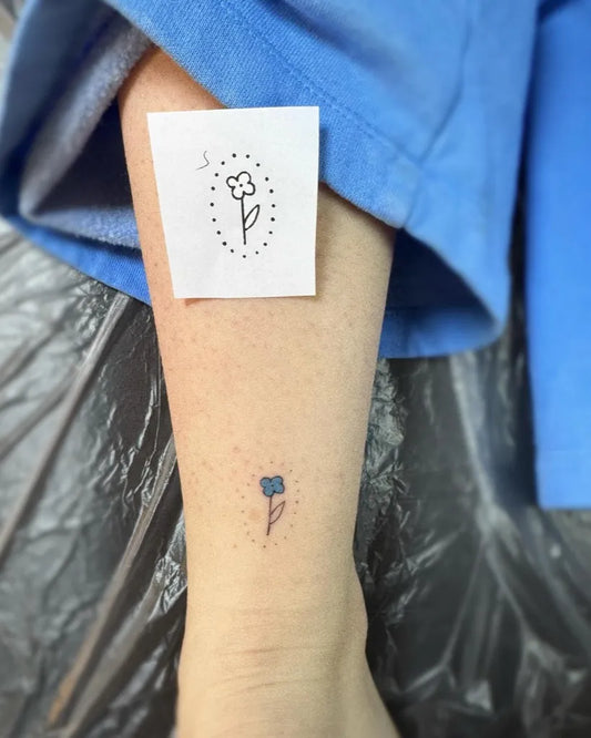 Tiny Blue Flower Tattoo on Women Leg by @emrystattoos