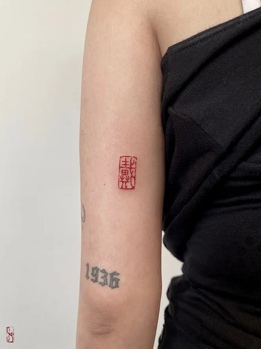 Tiny Chinese Red Seal Tattoo on Women UpperArm by @koiw_tattoo