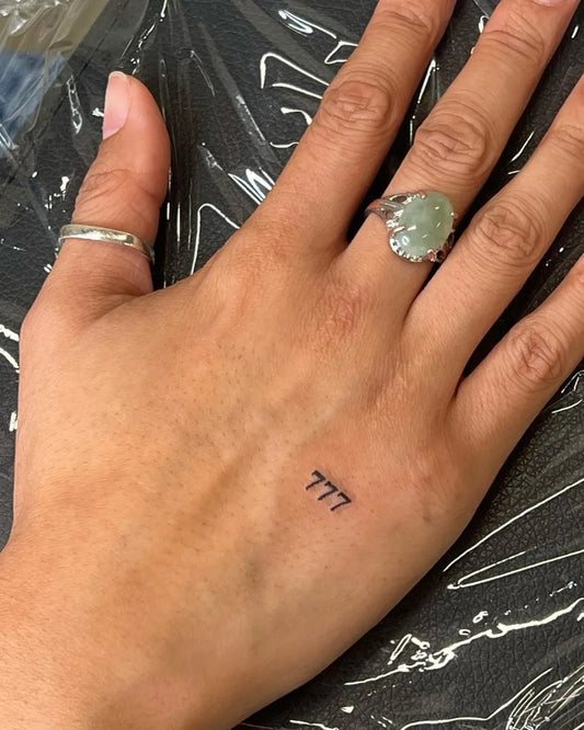 Tiny Fine Line 777 Tattoo on Women Hand by @hexgirljules