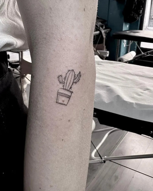 Tiny Fine Line Cactus in Pot Tattoo on Women Arm by @sailorstattoomilanomoscova
