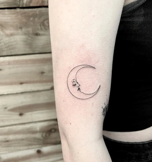 Tiny Fine Line Crescent Moon Face Tattoo on Women Arm by @evil_twin_tattoo