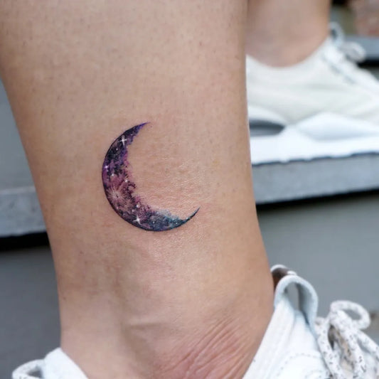 Tiny Fine Line Crescent Moon with Galaxy Tattoo on Women Ankle by @tattooer_manda