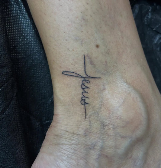 Tiny Fine Line Cross Jesus on Women Ankle Tattoo by @inkedbysky