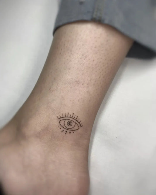 Tiny Fine Line Evil Eye on Women Ankle Tattoo by @finelinetattooslondon