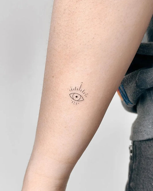 Tiny Fine Line Evil Eye on Women Arm Tattoo by @cha.tattoo