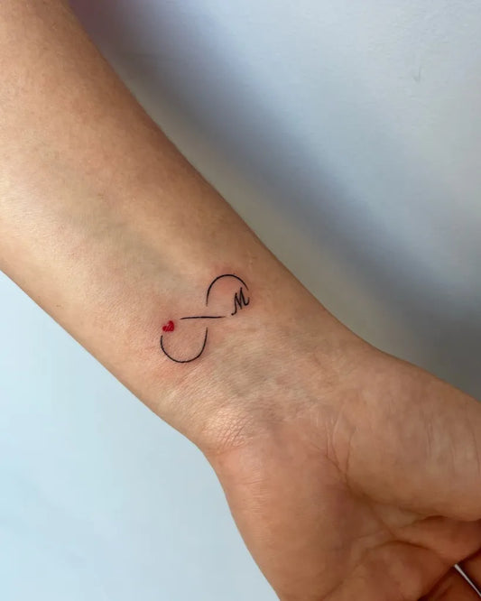 Tiny Fine Line Infinity Symbol with Heart and Letter Tattoo on Women Wrist by @zaratattoo_13