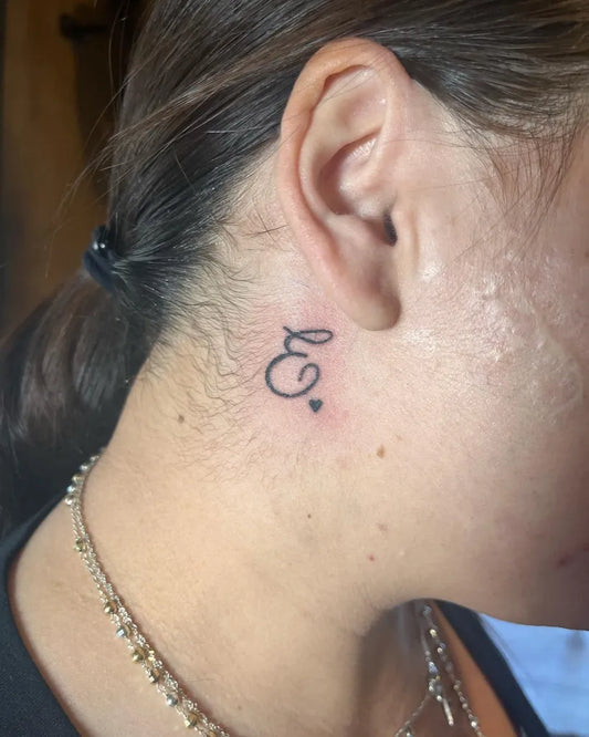 Tiny Fine Line Initial Heart Tattoo on Women Behind the Ear by @alexismarijke.art